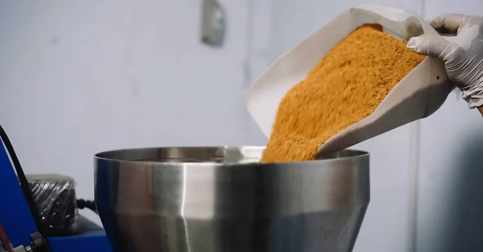 Arenga granules poured into a stainless steel hopper